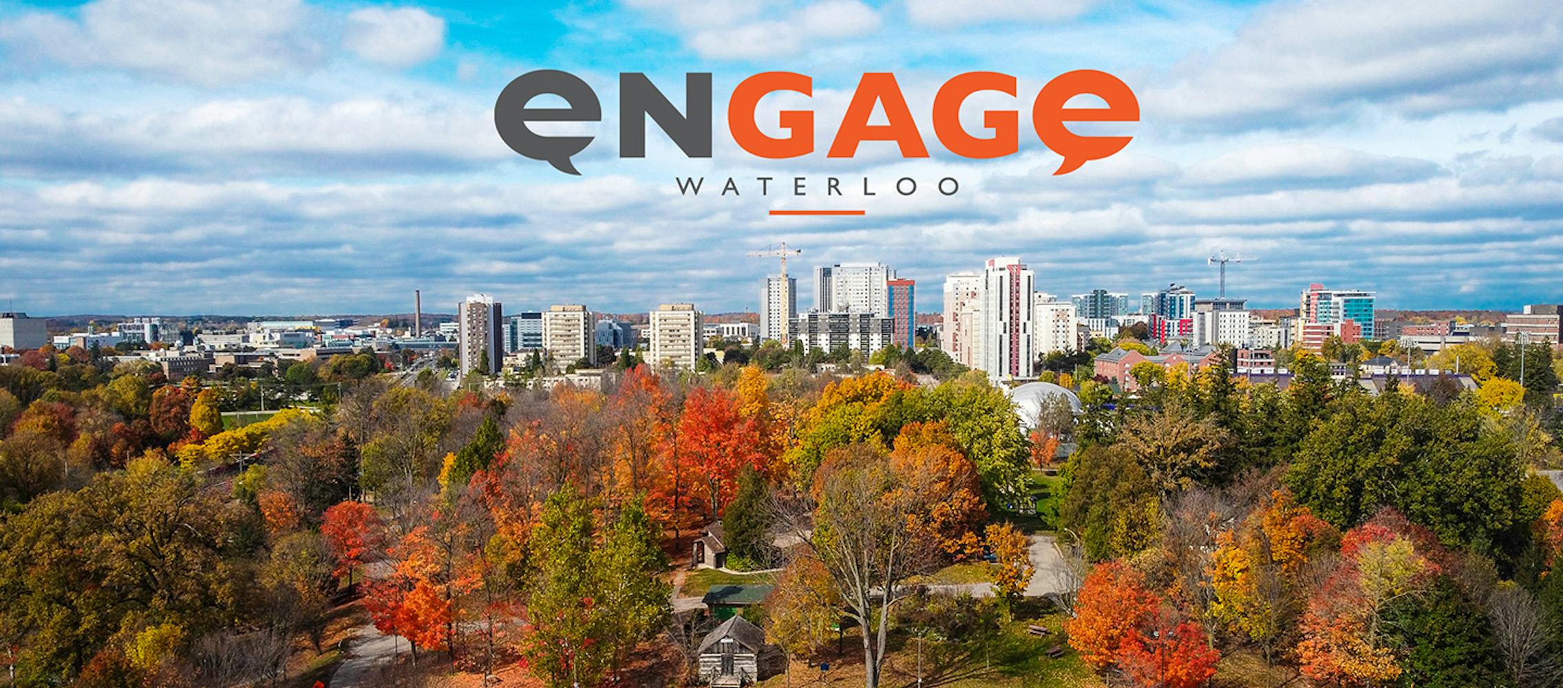 Aerial view of Waterloo in fall, with colourful trees in the foreground and the city skyline in the distance. The Engage Waterloo logo appears at the top.
